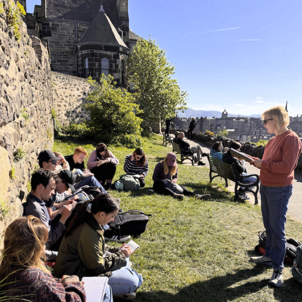 Sarah Crowley speaks to students sitting on the grass at Calton Hill in Edinburgh